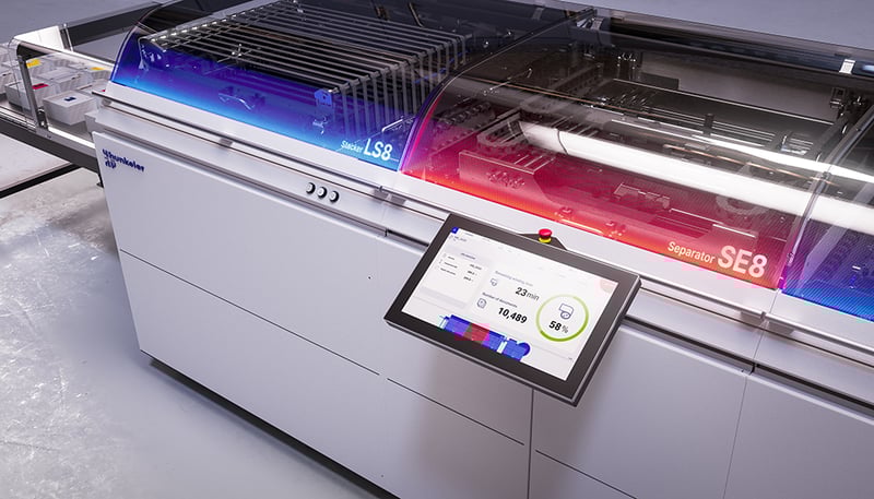 Nahaufnahme der Hunkeler GEN8 EVO Steuerkonsole mit Touchdisplay, zeigt Maschinenstatus und Fortschrittsanzeige, im Vordergrund Separator SE8 und Stacker LS8.