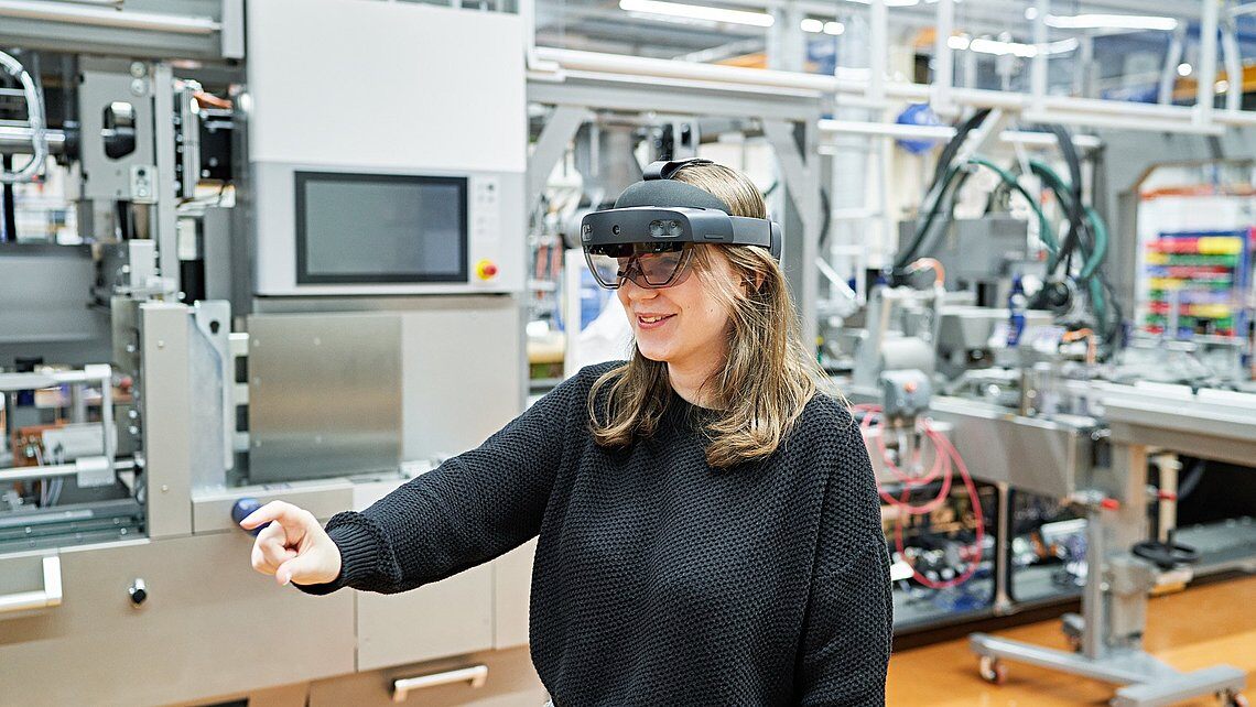An employee uses a HoloLens with the Körber Pharma Line Optimizer to optimize production processes in the pharmaceutical industry.