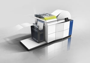 Hunkeler GEN8 EVO – Hochmodernes Digitaldruck-Finishing-System mit innovativem Industrial Design von Alphagate. Die transparente Schnittansicht zeigt die Papierverarbeitung, während das gelbe Licht eine Warnung signalisiert.